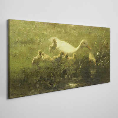 Tableau sur toile Un canard avec des poussins dans l'herbe