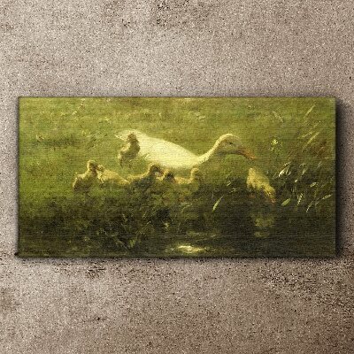 Tableau sur toile Un canard avec des poussins dans l'herbe