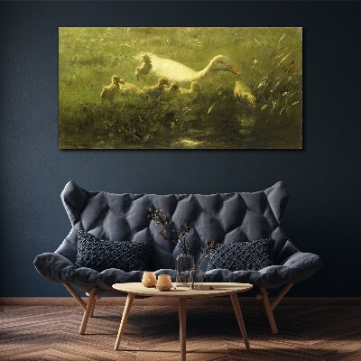 Tableau sur toile Un canard avec des poussins dans l'herbe
