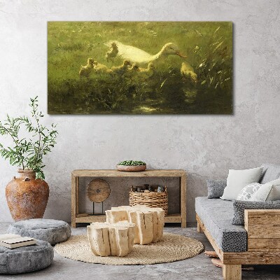 Tableau sur toile Un canard avec des poussins dans l'herbe