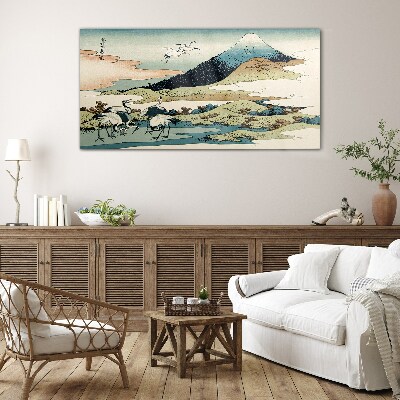 Tableau imprimé sur verre Grues près d'une montagne