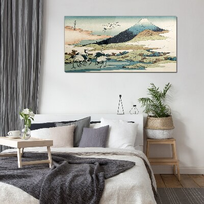 Tableau imprimé sur verre Grues près d'une montagne