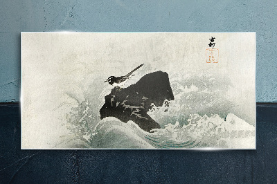 Tableau photo sur verre Un oiseau sur un rocher dans les vagues
