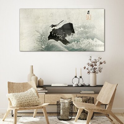 Tableau photo sur verre Un oiseau sur un rocher dans les vagues
