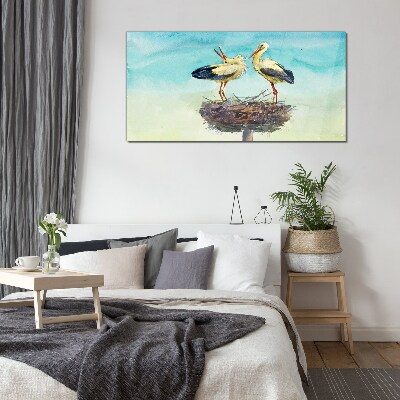 Tableau en verre Cigognes sur un nid dans le bleu