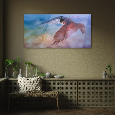 Tableau sur verre Vol d'un oiseau de proie dans les nuages