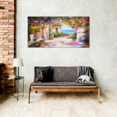 Tableau photo sur verre L'allée fleurie d'un village balnéaire