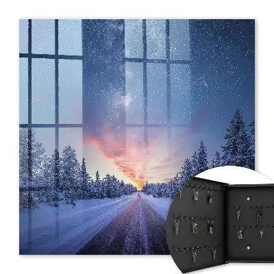 Des étoiles au-dessus de la route dans la forêt hivernale
