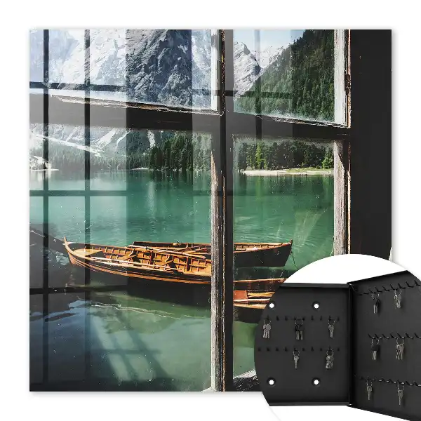 Tableau représentant un lac entouré de montagnes avec des bateaux devant une fenêtre