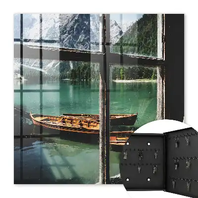 Tableau représentant un lac entouré de montagnes avec des bateaux devant une fenêtre