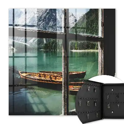 Tableau représentant un lac entouré de montagnes avec des bateaux devant une fenêtre