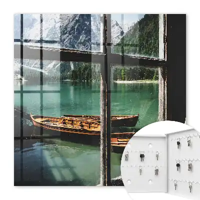 Tableau représentant un lac entouré de montagnes avec des bateaux devant une fenêtre
