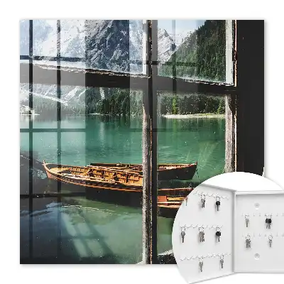 Tableau représentant un lac entouré de montagnes avec des bateaux devant une fenêtre